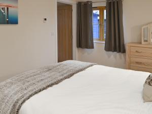 a bedroom with a white bed and a window at Dairy Cottage in Alkham