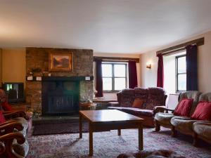 a living room with couches and a fireplace at Halford Big Barn in Halford