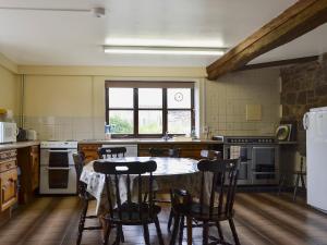 a kitchen with a table and chairs in it at Halford Big Barn in Halford
