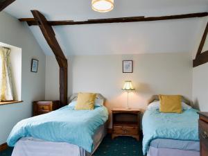 a bedroom with two beds and a lamp on a table at Halford Big Barn in Halford