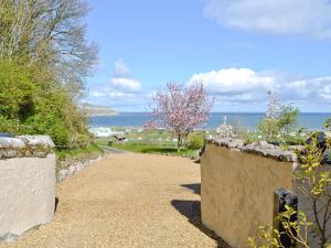 a stone path with the ocean in the background at Granary Cottage in Penrhyn Bay