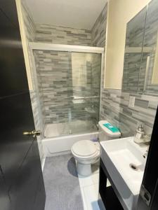 a bathroom with a toilet and a shower and a sink at Budget Single Room Near Central Park in New York