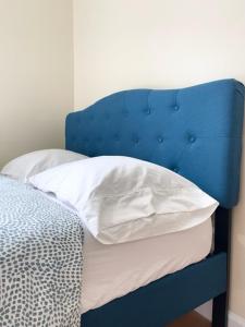 a blue bed with a white pillow on it at Budget Single Room Near Central Park in New York