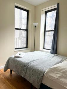 a bedroom with a bed and two windows at Budget Single Room Near Central Park in New York