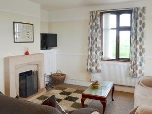 a living room with a fireplace and a window at Hafan - 28081 in Llangwnadl