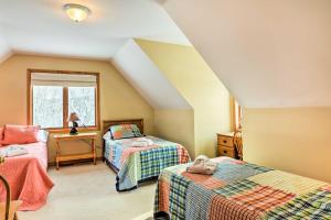 a attic room with two beds and a window at Mountaintop Ellicottville Home 7 Mi to Ski Resort in Ellicottville
