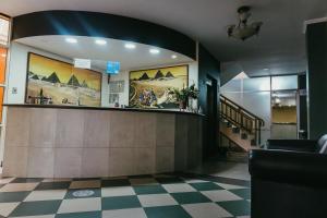 vestíbulo con mostrador de recepción y suelo a cuadros en Hotel Luxor, en Cochabamba