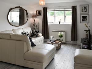 a living room with a white couch and a mirror at The Chicken Shed in Ruckinge