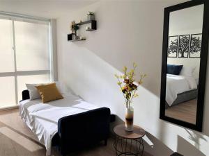 een woonkamer met een bed en een spiegel bij Cozy loft in La Candelaria in Bogota
