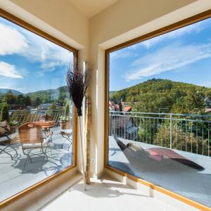 a balcony with a view of the mountains through a window at Plumbohms ECHT-HARZ-HOTEL in Bad Harzburg