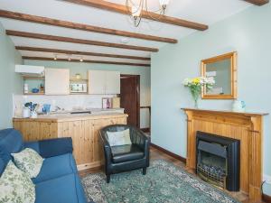 a living room with a blue couch and a fireplace at Apple Tree Cottage in Scalby