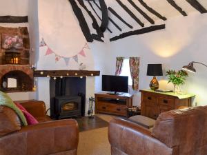 a living room with a couch and a fireplace at Childe Of Hale Cottage - 27896 in Hale