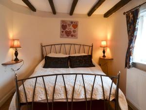 a bedroom with a bed with two lamps at Childe Of Hale Cottage - 27896 in Hale