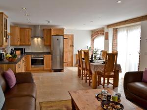 uma cozinha e sala de estar com um sofá e uma mesa em Paxton View Barn em Llanddarog