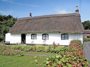 a white house with a thatched roof at Childe Of Hale Cottage - 27896 in Hale