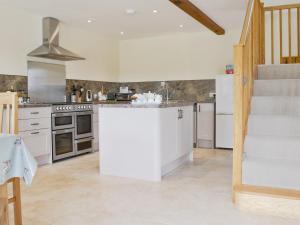 a kitchen with white appliances and a staircase at The Granary in Tytherton Lucas