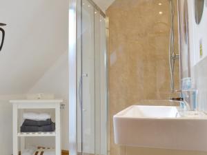 a white bathroom with a sink and a shower at The Granary in Tytherton Lucas