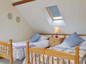 a bedroom with two twin beds and a skylight at The Granary in Tytherton Lucas