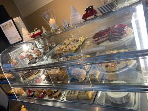 a display case filled with different types of pastries at Nygård Camping in Hjelle