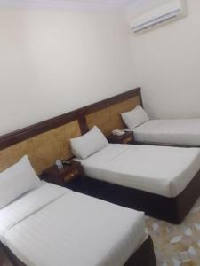 a room with two beds and two tables at اوتاد المتحدة in Al ‘Azīzīyah