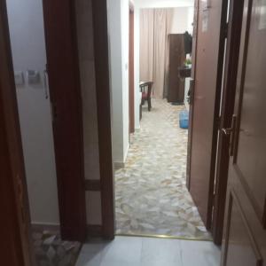 a hallway with a tile floor in a room at اوتاد المتحدة in Al ‘Azīzīyah