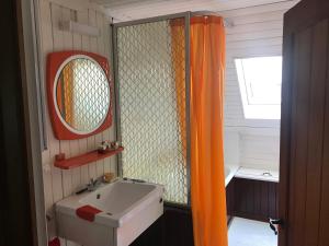La salle de bains est pourvue d'un rideau de douche orange et d'un lavabo. dans l'établissement Home@Chiny, à Chiny