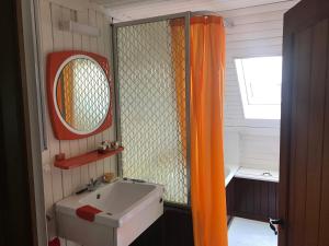 baño con cortina de ducha naranja y lavamanos en Home@Chiny, en Chiny