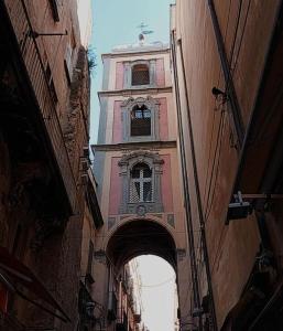 a tall building with a clock tower in an alley at La petite maison in Naples