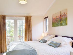 een slaapkamer met een bed met 2 kussens en een raam bij Oak Lodge in Clatworthy