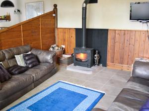 a living room with a couch and a wood stove at The Coach House - Exg in Upton