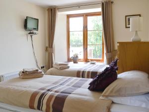 1 dormitorio con 2 camas y ventana en The Coach House - Exg, en Upton