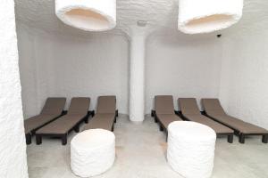 HVOYA Apart-Hotel & SPA في بوكوفِل: غرفة انتظار مع كراسي وجدران بيضاء وأضواء