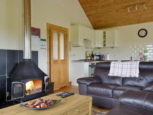 sala de estar con sofá y chimenea en Riverview Cottage, en Acharacle