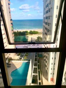 una ventana de un edificio con vistas al océano en Beach Class Executive, en Recife