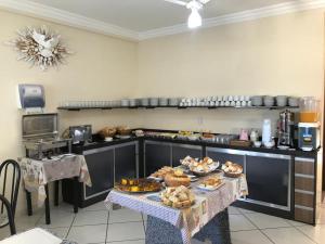 a kitchen with a table with some food on it at Pousada Soares in Aparecida
