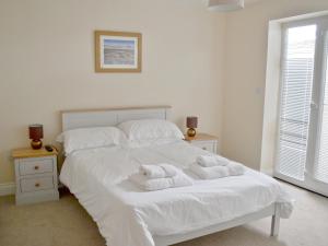 シーハウシズにあるCraster House At Seahousesのベッドルーム1室(白いベッド1台、タオル付)
