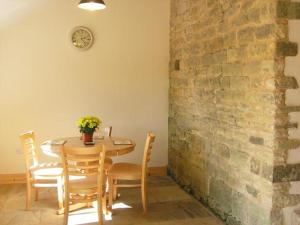 a dining room with a table and chairs and a brick wall at Pasture Barn in Lockton