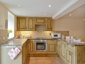 a kitchen with wooden cabinets and a sink at Bramble Cottage in Newland