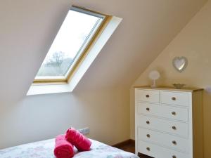 um quarto com uma janela, uma cama e uma cómoda em Bramble Cottage em Newland