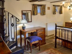 キャッスルトンにあるMushroom Cottageの木製デスクと鏡が備わる客室です。