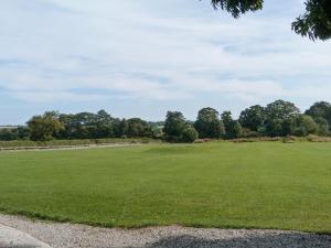 a large green field with trees in the background at The Stables in Hornsea