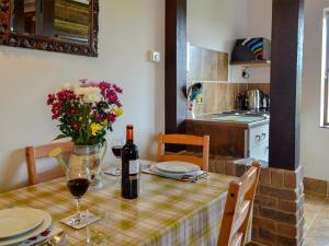 a dining room table with a bottle of wine and flowers at Apple Cottage - 27442 in Sedlescombe