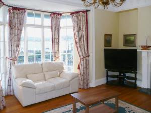 a living room with a white couch and a tv at The Captains House in Instow