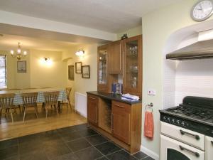 a kitchen with a stove top oven next to a dining room at The Captains House in Instow