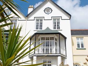 an exterior view of a white house with a balcony at The Captains House in Instow