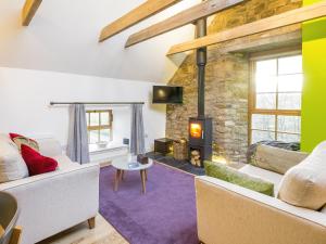 a living room with two couches and a fireplace at The Hayloft in Blitterlees