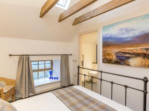 a bedroom with a bed and a painting on the wall at The Hayloft in Blitterlees
