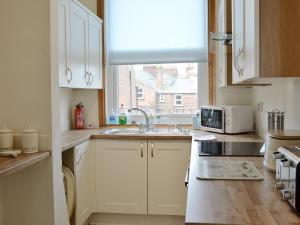 a kitchen with a sink and a window at Sea Views in Filey