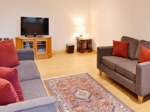 a living room with two couches and a flat screen tv at Tornahatnach - UK5177 in Alford