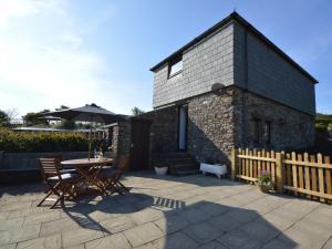 a house with a table and chairs and an umbrella at Buzzards View in Kingswear